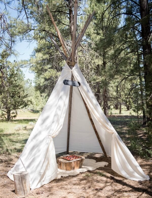 This outdoor woodland wedding set up a teepee for the kids to play in during the reception. Genius!