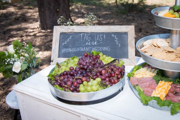 A simple white buffet adorned with sweets and treats for guests at an outdoor woodland wedding. So classic.