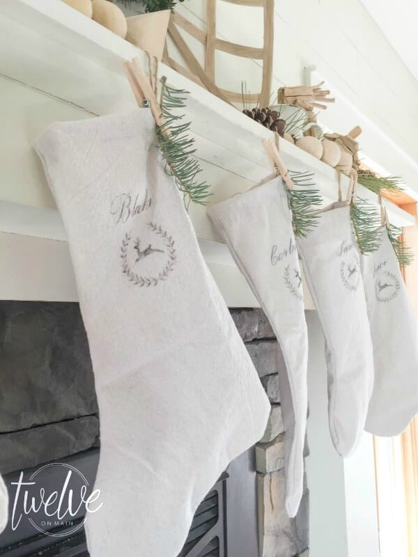 I love this farmhouse style Christmas mantel That driftwood reindeer is so perfect and those drop cloth stockings are amazing!