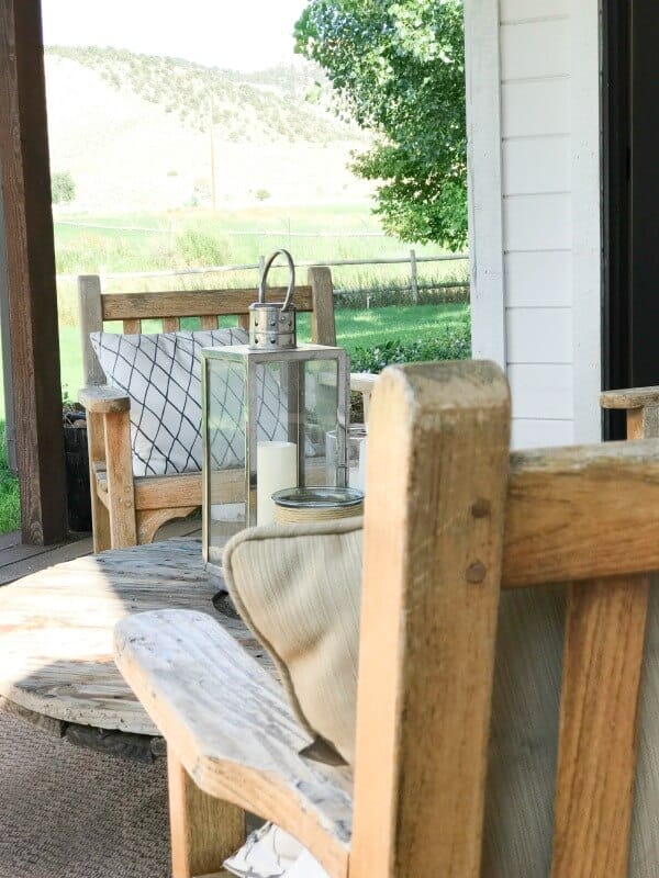 Lovely farmhouse summer porch decor! Love those lanterns and those teak chairs!