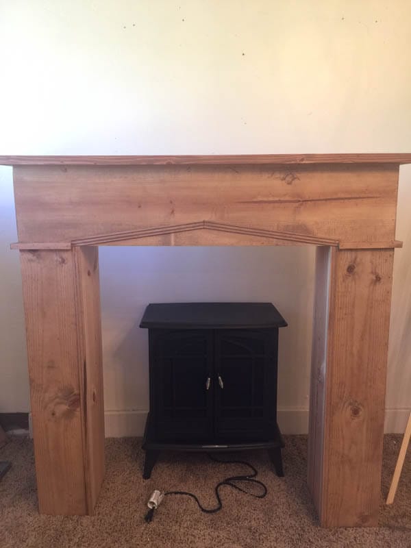 Add warmth, character and style to your home with this easy DIY faux farmhouse style fireplace and mantel. Raw wood, shiplap, and a freestanding fireplace!