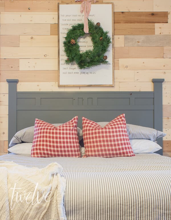 Boys bedroom decorate for Christmas with a wreath, holiday pillows, and twinkle lights.