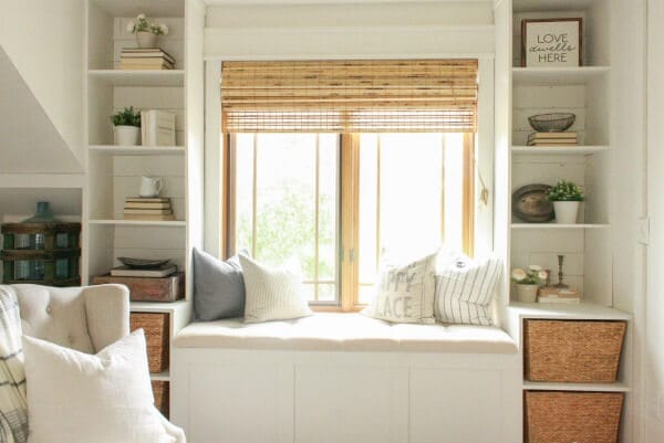Get cozy in this farmhouse style window seat with a cozy board and batten wall treatment and gorgeous farmhouse decor
