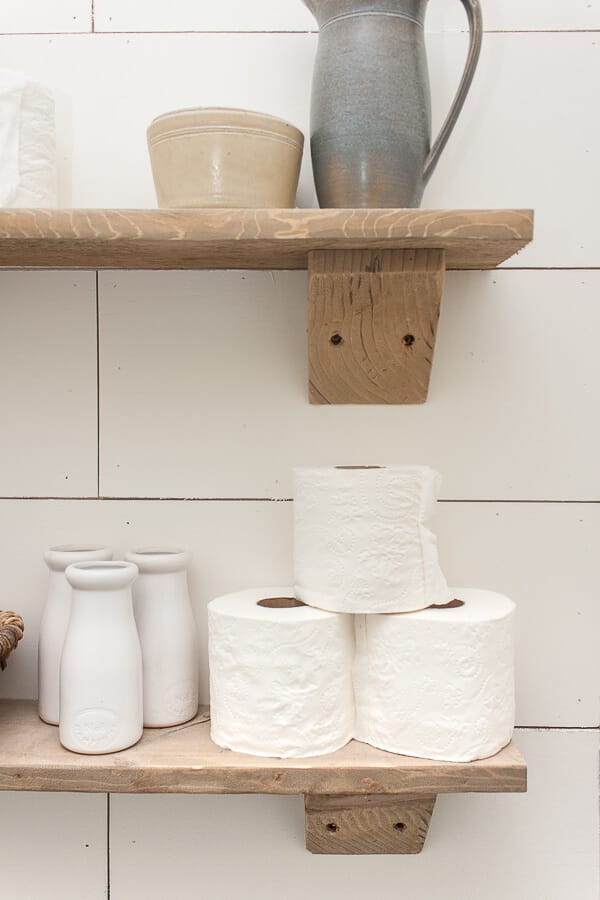 Use rustic wood shelves to store toilet paper in the bathroom. Great organization and stylish looks!