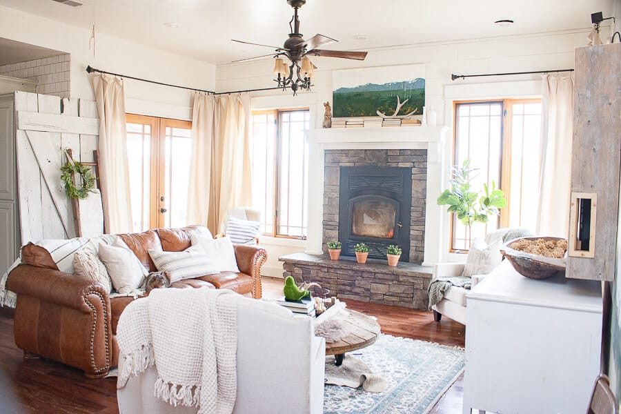 Calming farmhouse living room with canvas drop cloth curtains, farmhouse style artwork, and textured rugs and throws. Beautiful!