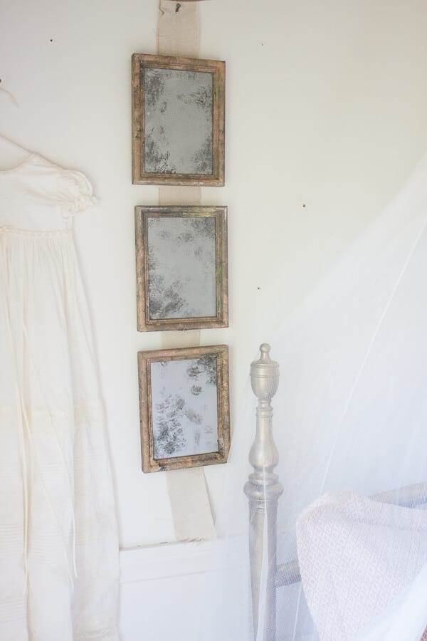 Little girls vintage french bedroom with vintage glass light and aged vintage mirrors made from old thrift store picture frames.