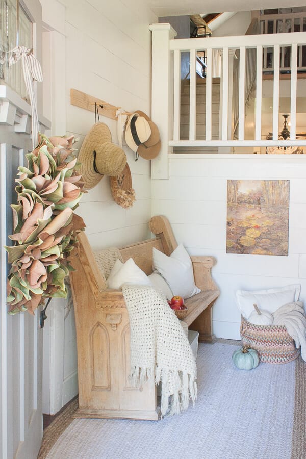 Farmhouse fall decor in the entry. Entryway fall decor, with neutral layers of texture and pops of color.