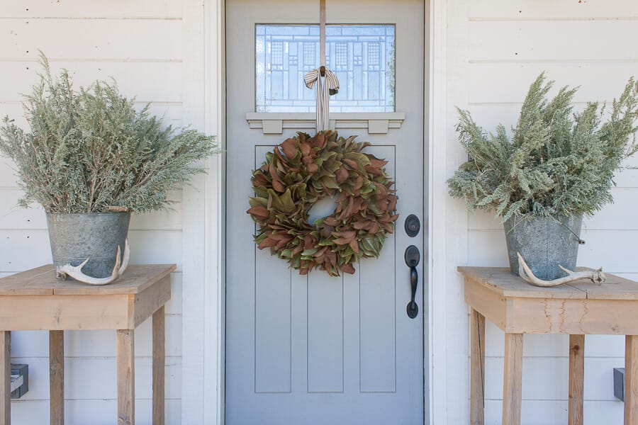 Fall decor on the porch with a magnolia wreath and zinc buckets with sagebrush