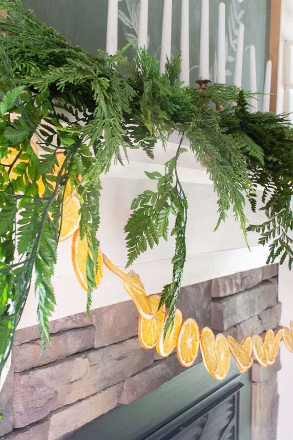 Dried orange garland and fresh greenery on the mantel for Christmas!
