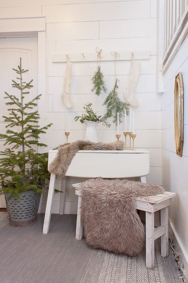 White walls, white furniture, fresh cut Christmas tree, Scandinavian Christmas elements including furs, fresh natural elements, and a touch of metal.