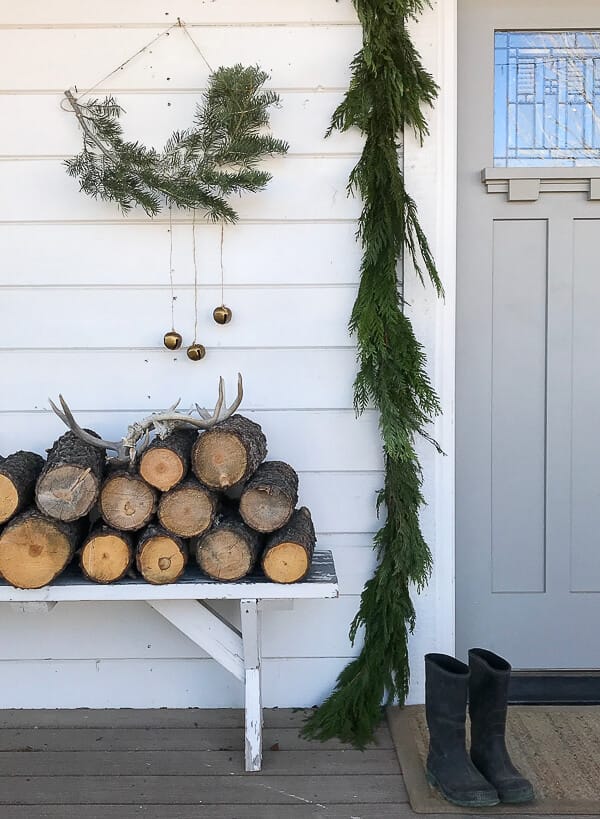 Scandinavian Christmas porch decor including fresh garland, handmade nordic wall hanging, and simple elements that keep Christmas calm this year