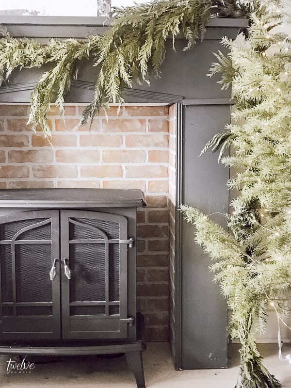 I love everything about this shot! Mantel painted with Farrow and Ball Downpipe, brick insert is amazing and the real evergreen garland is amazing!