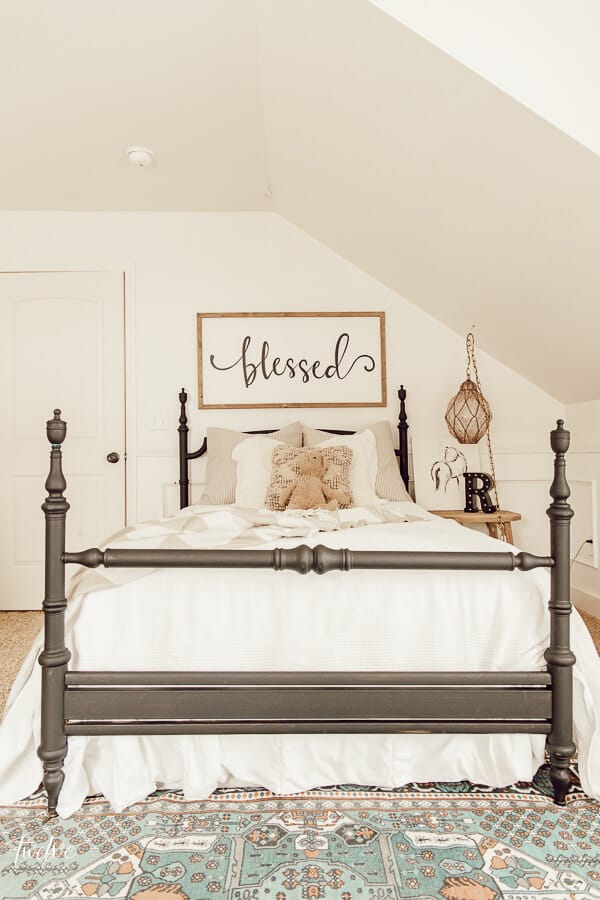 A little girls bedroom dream! Love the black bed, layered textures, a pop of color on the rug and the vintage glass light hanging above the nightstand!