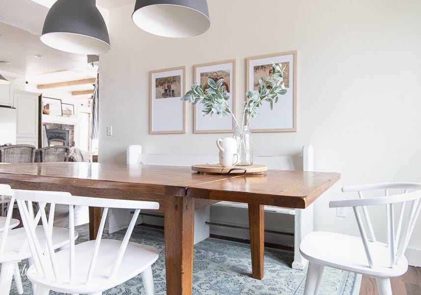 Custom framed art, IKEA Hektar lights, an incredible Mohawk rug, and the most incredible white spindle chairs  round out this modern farmhouse dining room design!