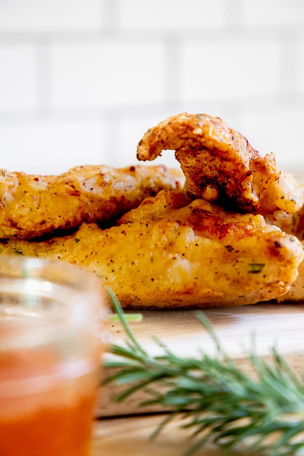 You will never believe what I use to make the crispiest fried chicken ever! Its Argo corn starch! This fried chicken recipe is full of savory herb batter, a touch of spice with Sriracha sauce and a sweet and spicy honey Sriracha dipping sauce that is the perfect compliment to the flavorful fried chicken.