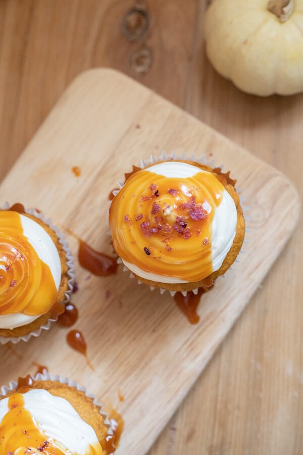 Utterly decadent fall inspired pumpkin cupcakes topped with cream cheese frosting, caramel and sea salt. It has all the flavors of fall! 