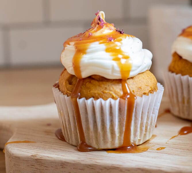 The easiest pumpkin cupcake recipe with cream cheese icing, caramel sauce drizzle and topped with a pinch of sea salt! This cupcake is perfect for fall!