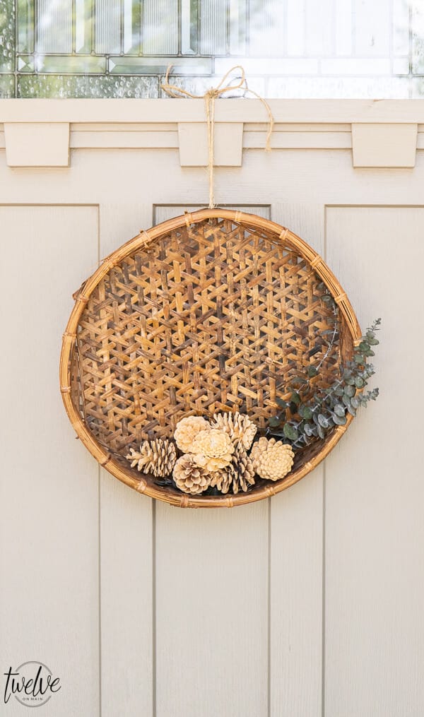 Fall wreath with eucalyptus, pine cones and a rustic basket give all the gorgeous earthy tones perfect for the autumn weather.