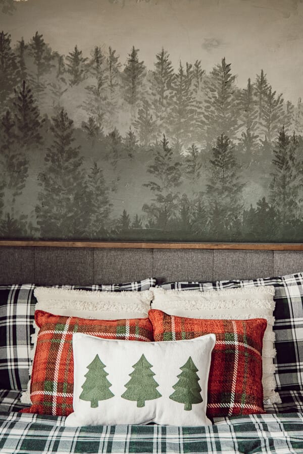 This hand painted forest wall mural along with the plaid flannel sheets and simple Christmas pillows create the most magical kids Christmas bedroom!