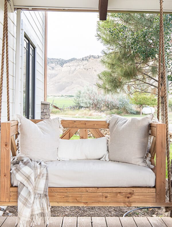 Make this easy DIY porch swing using these easy to follow building plans. This is stylish, and so cozy! Make sure to check it out!