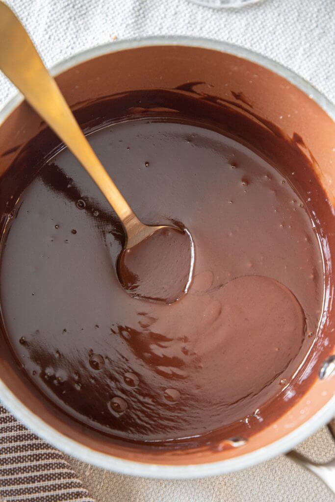 How to make a 2 ingredient chocolate sauce or chocolate ganache. This easy topping is the perfect chocolate sauce for ice cream, for cake,  and many other baked goods. With only 2 ingredients it is easy to make and can be stored in the fridge for a later use! Learn how to make it and what I love to use it on here! See more at www.twelveonmain.com