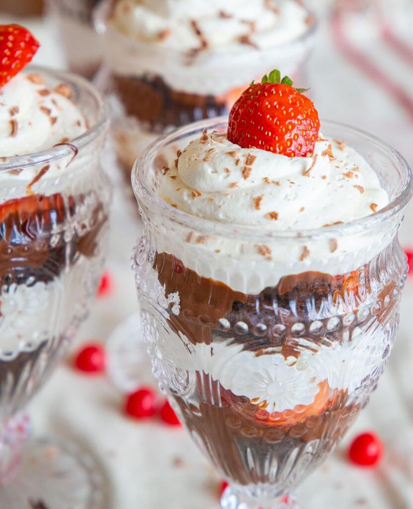 This is the best brownie trifle recipe. With the combination of brownies or chocolate cake, pudding/cool whip filling, strawberries, and homemade chocolate sauce, this is easy to make and looks amazing! It tastes amazing and is a sweet treat to make for Valentines Day or any day. Its a great Valentines dessert, and the individual trifles are adorable!