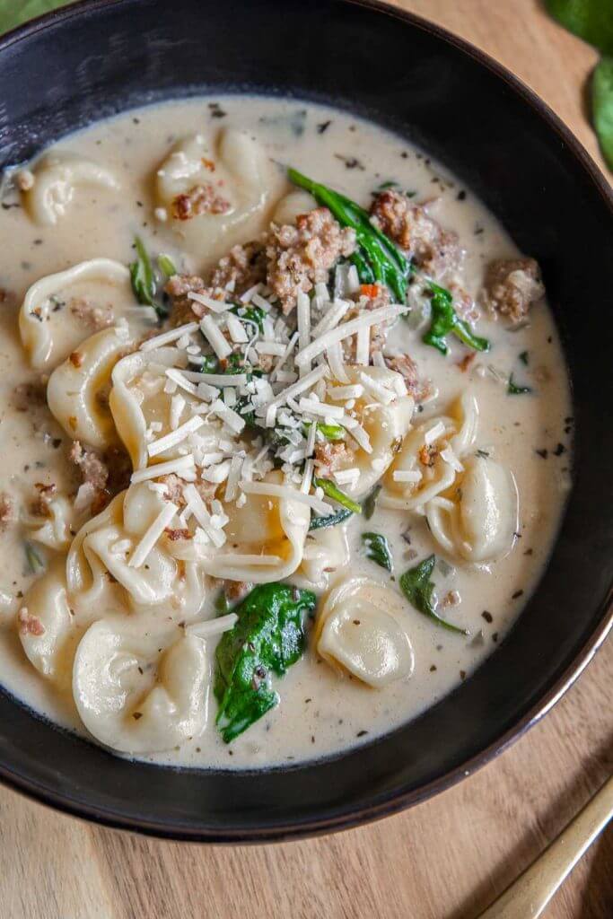 Make this creamy tortellini soup with sausage and spinach today! This is the perfect comfort food and is quick and easy to make.
