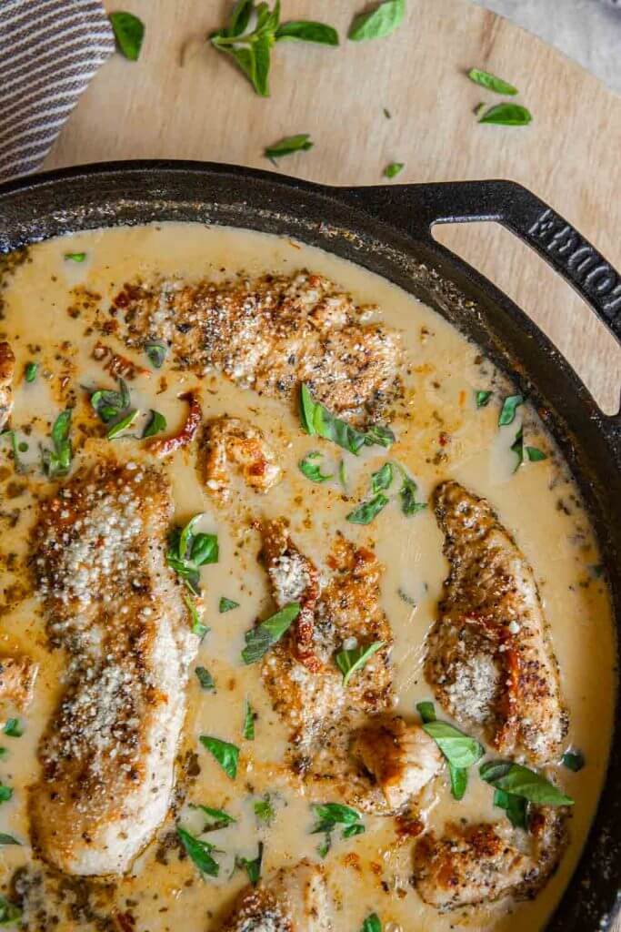 This amazing marry me chicken is on our our most popular dishes with a creamy sun-dried tomato sauce with garlic and parmesan. This chicken is bathed in a garlic and parmesan cream sauce and sun dried tomatoes. It is skillet cooked and finished in the oven with tender fall apart chicken breasts. Serve with pasta, or your favorite veggies side.