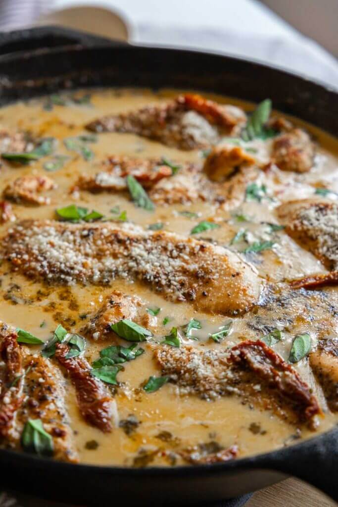 This amazing marry me chicken is on our our most popular dishes with a creamy sun-dried tomato sauce with garlic and parmesan. This chicken is bathed in a garlic and parmesan cream sauce and sun dried tomatoes. It is skillet cooked and finished in the oven with tender fall apart chicken breasts. Serve with pasta, or your favorite veggies side.