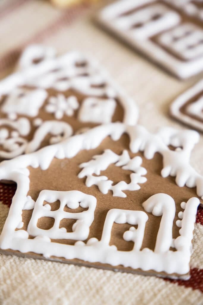 Make these easy gingerbread house ornaments using craft or chipboard, a Cricut Machine, homemade puff paint and more!