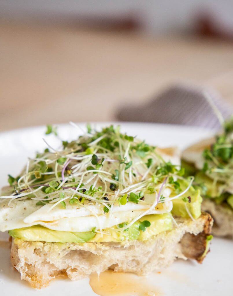 This hearty and healthy sourdough breakfast sandwich with eggs, avocado, microgreens, hot honey and sea salt is the perfect balanced breakfast. It is so full of flavor and is a perfectly balanced meal.