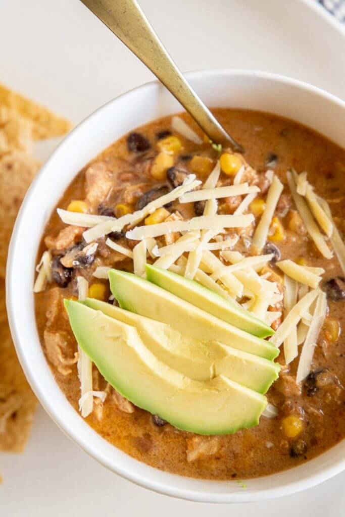 Easy to make creamy tortilla soup with chicken, beans, corn and more. Can be made in  the crock pot or on the stovetop! It is so flavorful!